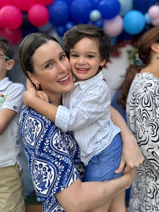 Una madre abraza a su hijo en una celebración de Colorpillars