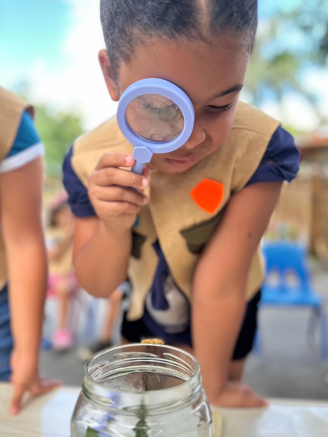 Un niño observa la naturaleza con una lupa en Colorpillars